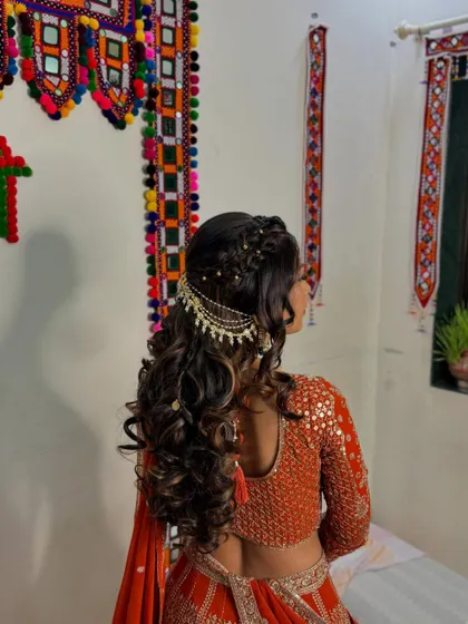 A detailed look at the back of her hairstyle, featuring a beautiful braid and curl combination with an elegant hair accessory.