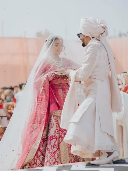 A beautiful, romantic shot of the couple during their Varmala ceremony, framed by the bride's delicate veil.