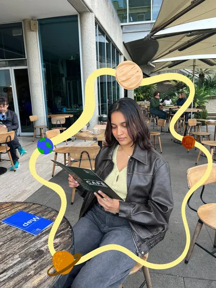 A universe of thoughts while looking at a menu. I drew a little solar system around myself to add a whimsical, cosmic vibe to a simple cafe photo.