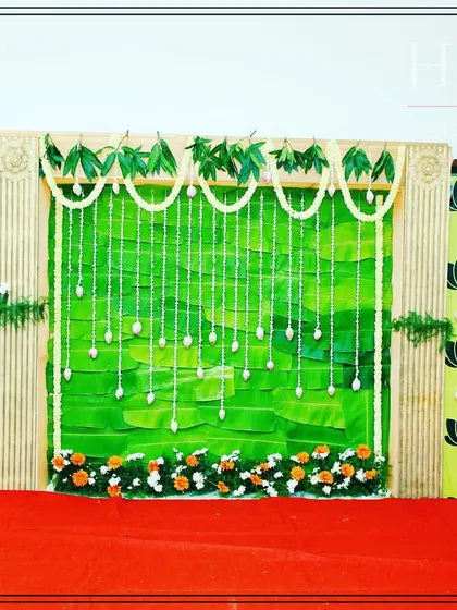 A clear view of the Seemantham backdrop. The combination of a pleated green center, lotus print panels, and jasmine flower garlands provides a fresh and traditional look.