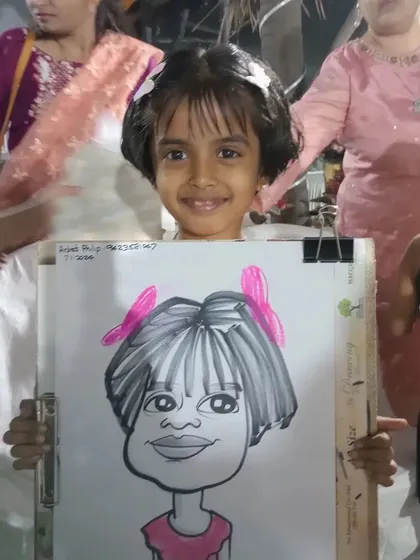 Another young guest at the birthday party, proudly holding her new drawing.