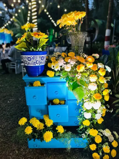 A creative decor piece using a blue chest of drawers, with flowers spilling out of the open drawers for a whimsical touch.