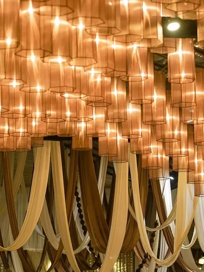 A ceiling that feels like a starry night. This canopy of glowing cylindrical lamps casts a soft, magical glow, creating an ethereal ambiance that is a perfect harmony of warmth and grace.
