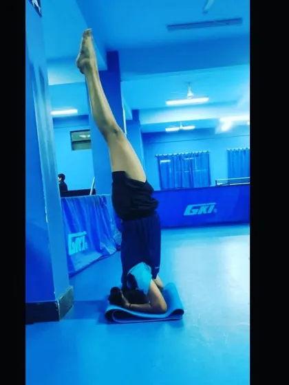 A player performs a supported headstand (Sirsasana) to build upper body strength and improve circulation, a key part of our advanced yoga practice for athletes.