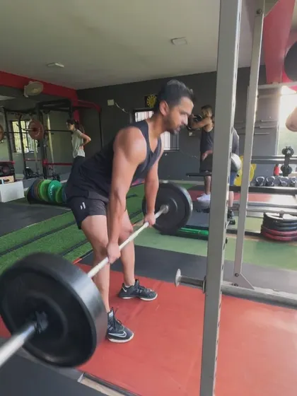 A client performs a Romanian deadlift, focusing on the hamstring stretch and posterior chain engagement.