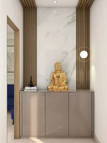 This narrow entryway is maximized with a slim, floating console table. A golden Buddha statue sits atop, framed by a marble-effect panel and a modern circular pendant light.