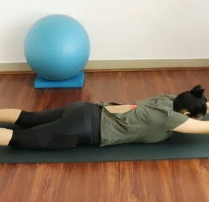 A demonstration of a spinal extension exercise, perfect for new moms looking to regain strength in their posterior chain.