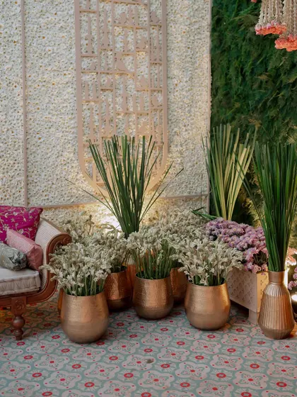 A detail shot of a seating area with brass pots filled with fresh tuberoses. The combination of metallic accents and fragrant white flowers is a classic and elegant choice.