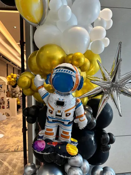 An astronaut balloon sculpture, adding a fun and thematic touch to the space-themed party.