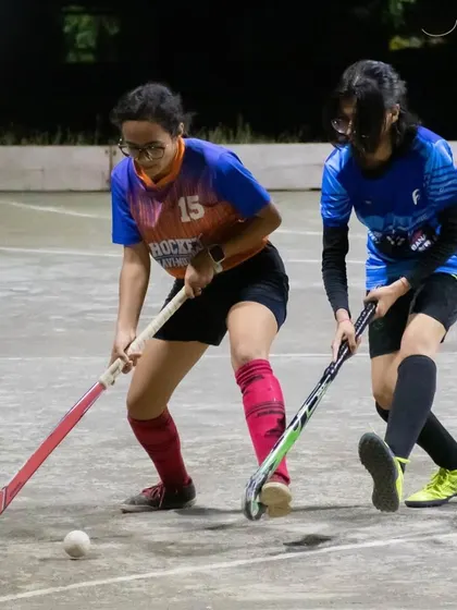 Two players face off for the ball during the night exhibition match. These competitive encounters are excellent for skill development.