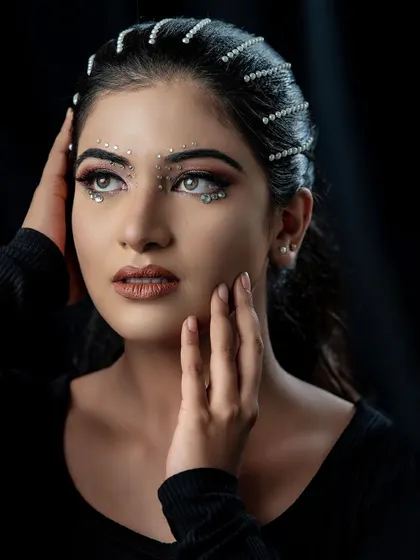 A dreamy and artistic shot of this high-fashion look. The model's gaze and the unique makeup come together to create a captivating and memorable image.
