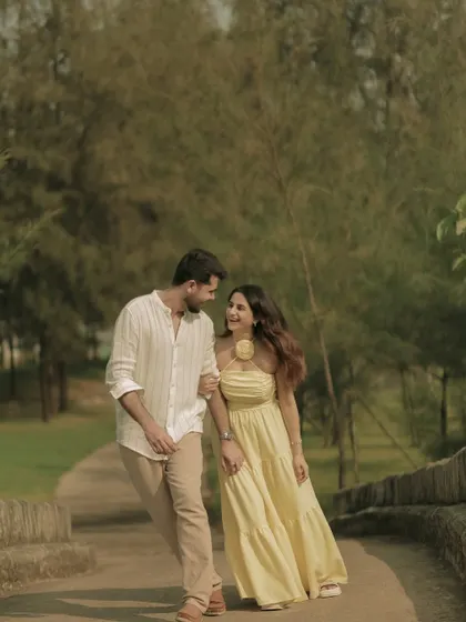 A romantic walk through a park, capturing a natural and happy interaction between the couple.