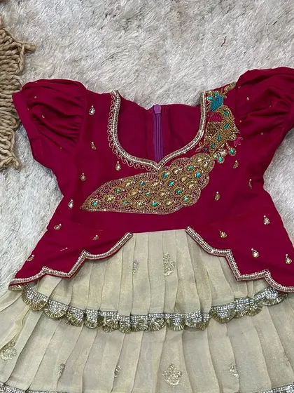 A close-up of the bodice, showing the intricate peacock embroidery with bead and stonework.