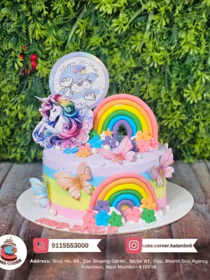 A whimsical unicorn and rainbow cake with butterfly accents. The pastel colours and multiple rainbows create a beautiful and enchanting birthday cake.