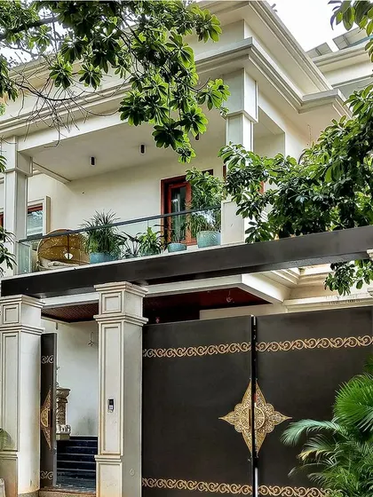'The White House' in Bangalore features a classic, elegant exterior with subtle ornamentation. The grand gate and pillars are framed by lush greenery, creating a perfect blend of tranquility and luxury.