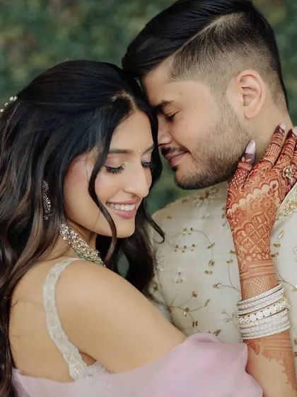 A beautiful, intimate moment from an engagement. Her pastel lehenga is paired with a soft glam makeup look, featuring a gentle shimmer on the eyes and a natural, glossy lip.