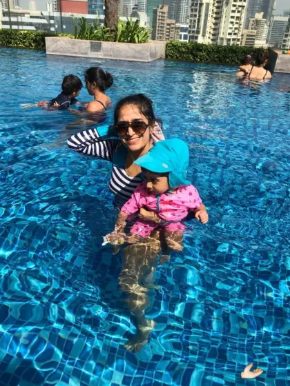 A happy mom and baby enjoying a sunny day in the pool during their lesson.