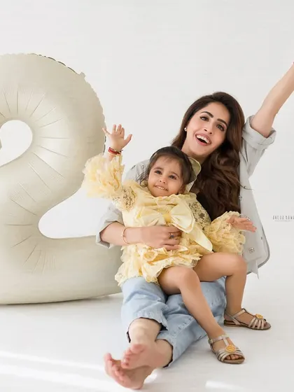 Pure joy and celebration! A mother and daughter wave happily during a fun and energetic second birthday photo session.