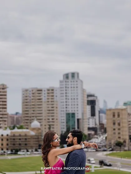 The couple shares an embrace with the Baku city skyline as their backdrop.