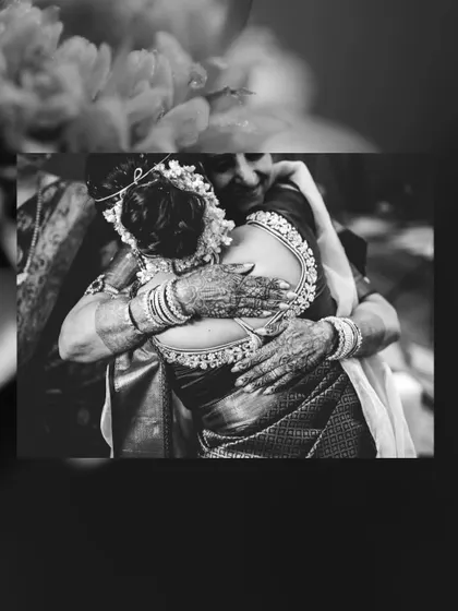 A deeply emotional black and white photo of a bride hugging a family member, a moment filled with love and blessings.