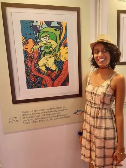 Me standing next to my framed artwork at the Majhi Metro exhibition. This piece, "Magic," was my winning entry.