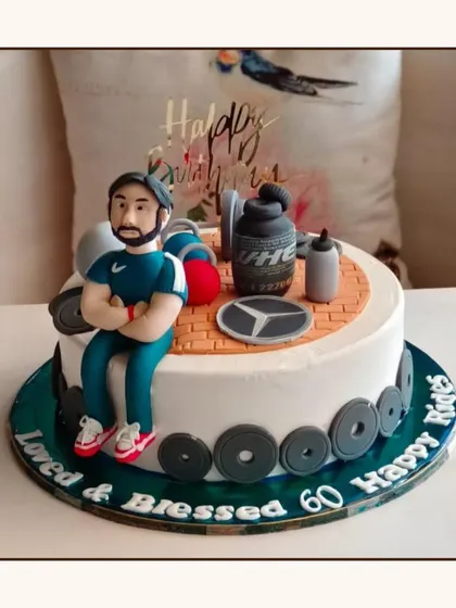 A fitness-themed cake for a 60th birthday, decorated with gym equipment, weights, and a fondant figure of a fitness enthusiast.