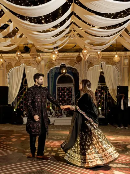 The couple shares their first dance on the custom-designed floor, under a ceiling of draped fabric and hanging lanterns.