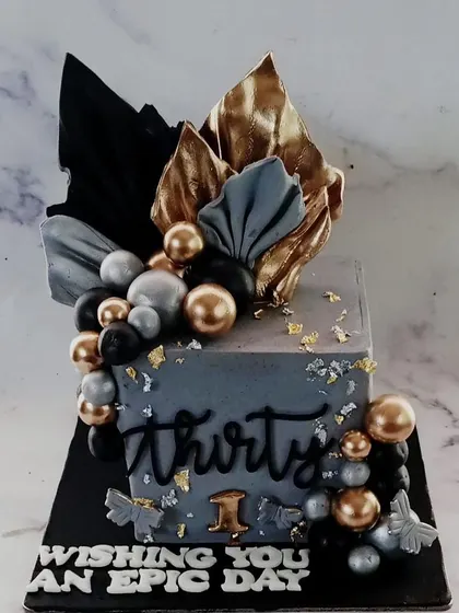 A still shot of our sophisticated 30th birthday cake. The combination of grey fondant, black and gold accents, and sharp edges makes for a powerful and stylish statement piece.