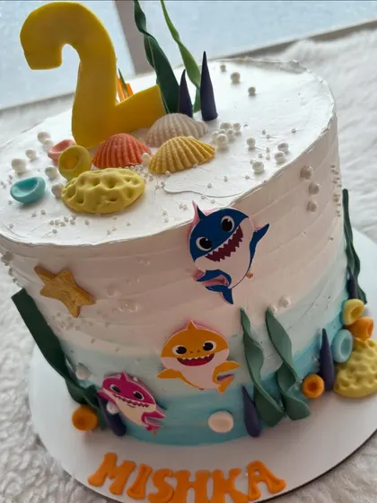 Doo doo doo! A Baby Shark cake for a second birthday. The design features an underwater scene with the whole shark family and edible seashells.