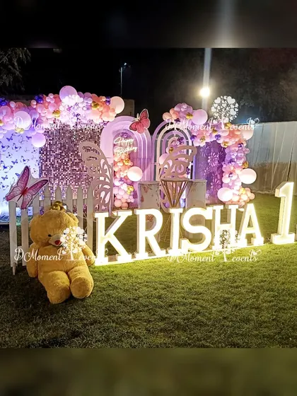 The butterfly-themed stage illuminated at night, showcasing the sparkling sequin wall and the soft glow of the marquee letters.