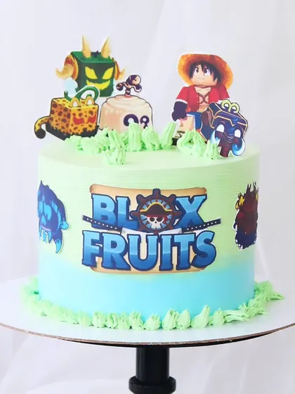 A Blox Fruits gaming-themed cake for a fan of the popular online game. This design features an ombre buttercream finish and is decorated with edible prints of the game's characters and logo.