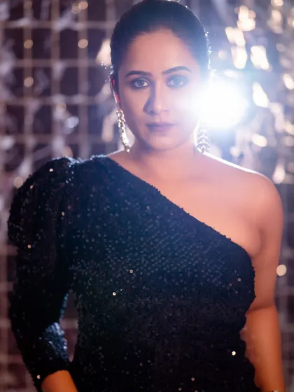 Another shot from the same glamorous session, this time focusing on a direct, confident look. The shiny background and key light create a vibrant, celebratory feel.