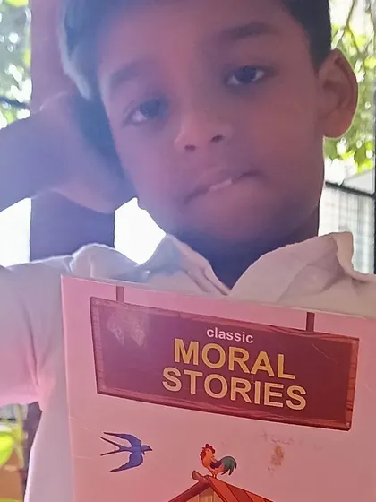 A boy with his book of moral stories.