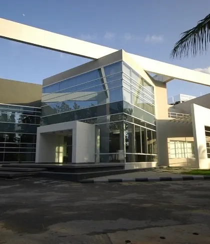 The front facade of the Komet India headquarters in Bengaluru, completed in 2007. This project demonstrates our capability in designing large-scale corporate structures. The design features an expansive glass curtain wall for transparency and a striking white structural frame that defines the building's modern character.