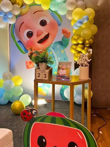 A detail shot from a Cocomelon party, showing a small table with a photo of the birthday boy and a calendar block marking the special date.