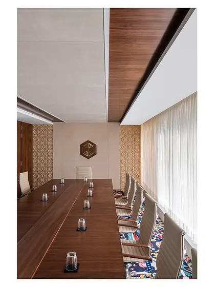 The Vivanta meeting room in 'The Office with A View' uses the brand's signature purple in its carpet and fabric wall panels. The darker veneer and premium finishes distinguish this as a more exclusive meeting space within the headquarters.