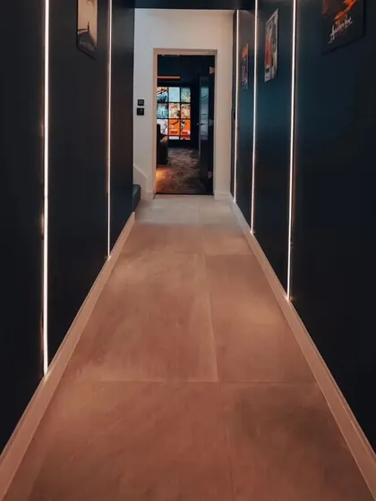 A shot of the entryway corridor leading to the theater. The vertical LED strips on the walls create a dramatic and futuristic welcome.