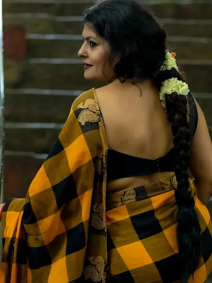 Another angle of the checkered Kanchi cotton saree, this time with my hair in a traditional braid. This demonstrates how a simple change in hairstyle can alter the entire vibe of an outfit.