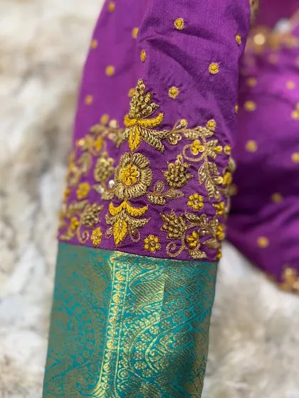 A detailed shot of the sleeve embroidery, highlighting the texture and richness of the threadwork.