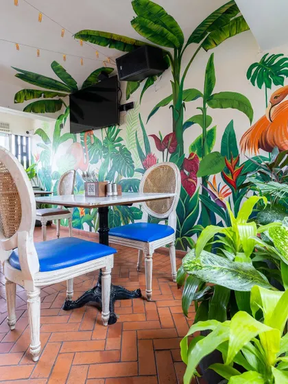 A vibrant, tropical mural in a restaurant, featuring a large flamingo. This kind of custom artwork can completely define the atmosphere of a commercial space.