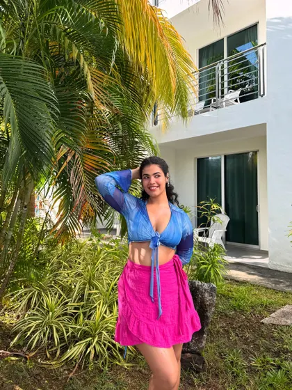 Me and my one brain cell on an island. This colorful look with a blue tie-front top and a bright pink skirt is all about dopamine dressing. Vacation is the perfect time to play with bold color combinations.