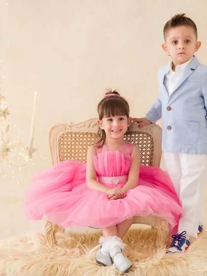 A formal yet sweet portrait of a brother and sister. She sits elegantly on a vintage chair while he stands proudly beside her.