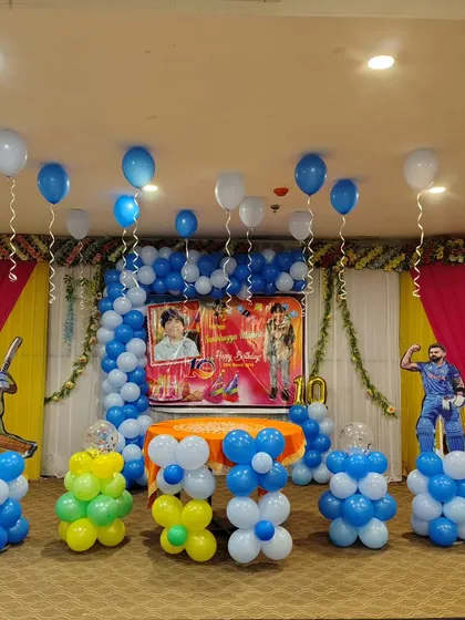 A full view of the cricket themed birthday decoration. I use balloon columns and floating balloons to fill the space and match the main stage backdrop, ensuring the theme is visible from all angles.