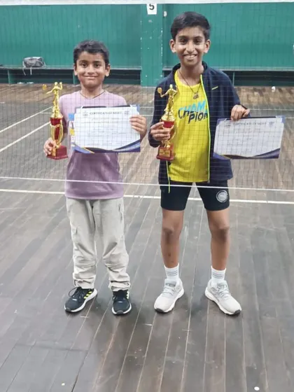 Young champions Ajinkya Desai and Kaavya Parmar showing off their trophies after winning their respective district-level tournaments.