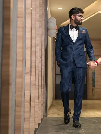 A wedding day is also a journey. This candid shot captures the couple walking hand in hand, sharing a private moment away from the crowd. The leading lines of the corridor create a dynamic composition for this reception photograph.
