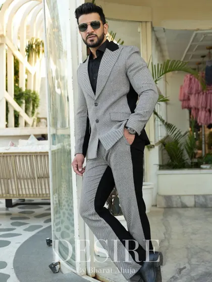 Leaning with confidence, this image showcases the sleek silhouette of the grey and black color-blocked suit. It’s a look that is both modern and timeless.