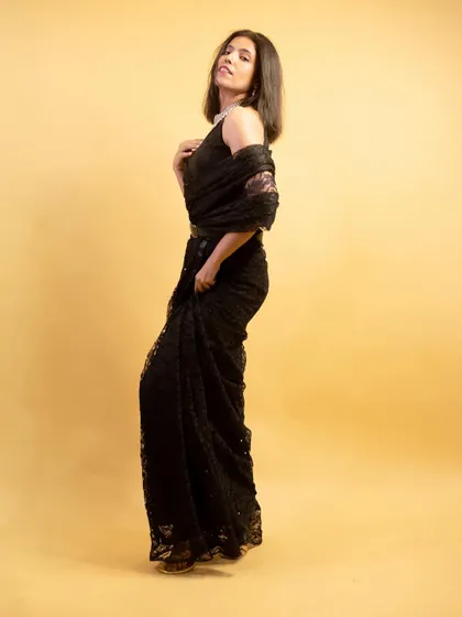 This profile shot in a black lace saree emphasizes the garment's texture and my pose, conveying a sense of drama and elegance.