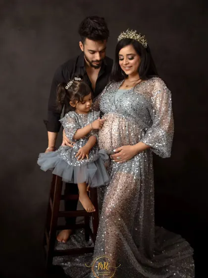 A sweet moment where the older sister interacts with her mother's baby bump. This shot captures the anticipation and love within the growing family.