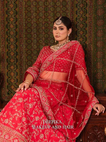 The bride seated, showcasing the beautiful embroidery and the sheer dupatta. The pose is graceful and classic.