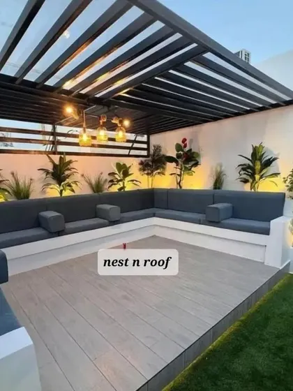 This modern pergola design features a metal frame and includes custom-built, L-shaped waterproof seating, maximizing comfort and space.